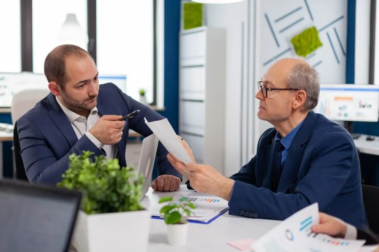 senior entrepreneur discussing with coworker holding documents conference briefing businessman discussing ideas with colleagues about financial strategy new start up company 482257 5074 1